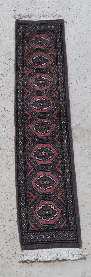 A pink ground Ozbeck runner with 8 octagons to the centre