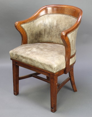 An Edwardian oak tub back chair upholstered in green rexine, raised on square tapering supports with H framed stretcher 