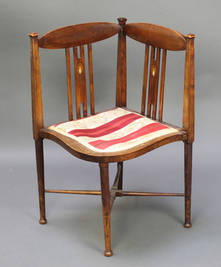 A Liberty's style Edwardian inlaid mahogany stick and rail back corner chair with shaped seat and X framed stretcher, raised on turned supports (some water damage)