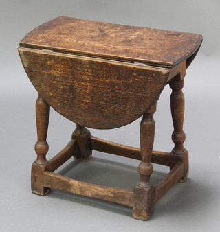 An oak oval drop flap occasional table raised on turned and block supports 18"h x 19"w x 10" when closed x 25 1/2" when open 