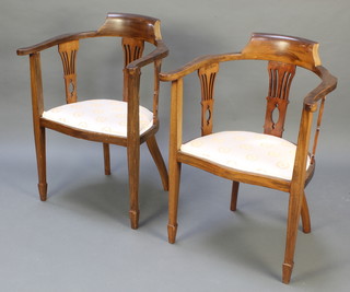 A pair of Edwardian mahogany slat back open arm chairs with pierced backs, raised on square tapering supports