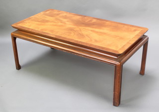 A Chinese style rectangular mahogany coffee table with quarter veneered top, raised on shaped supports 21"h x 49"w x 25 1/2"d 