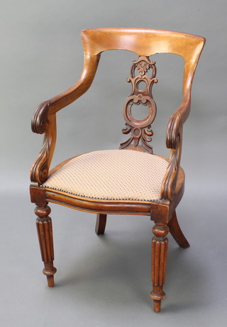 A Victorian mahogany tub back chair with carved and pierced splat back, the seat of serpentine outline, raised on turned and reeded supports 