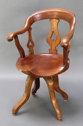 A 19th Century mahogany tub back revolving office chair with pierced slat back raised on scrolled supports 