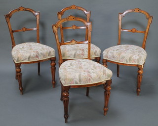 A set of 4 Victorian inlaid mahogany rail back dining chairs with shaped mid rails and upholstered seats, raised on turned and fluted supports 