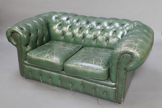 A 2 seat Chesterfield settee upholstered in green buttoned leather 25"h x 60"w x 35"d 