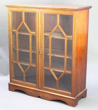 An Edwardian walnut display cabinet, fitted adjustable shelves enclosed by glazed panelled doors, raised on bracket feet 48"h x 41 1/2"w x 16"d 
