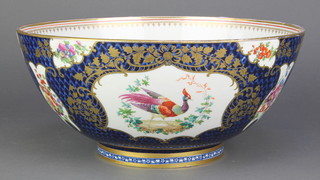 A Worcester style punch bowl, the blue scale ground with gilt panels of birds and flowers, the interior with insects and flowers 13" 