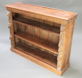 A Victorian carved oak bookcase fitted adjustable shelves and having carved panels with lion mask decoration to the sides 37"h x 48"w x 12"d 