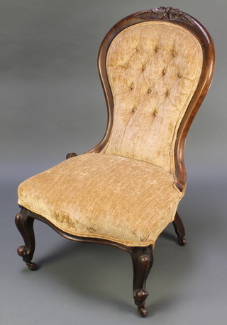 A Victorian mahogany show frame nursing chair upholstered in mushroom buttoned material, raised on cabriole supports 