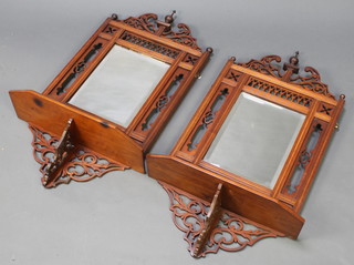 A pair of Victorian rectangular bevelled plate mirrors contained in pierced walnut frames incorporating a shelf 32"h x 16"w x 7"d 