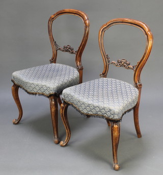 A pair of Victorian carved walnut balloon back dining chairs with shaped mid rails and seats of serpentine outline, raised on cabriole supports (frames loose)