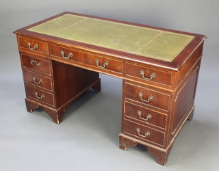 A mahogany kneehole pedestal desk with green inset writing surface, fitted 1 long and 8 short drawers 30"h x 54"w x 27"d 