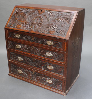 A 19th Century carved oak bureau, the fall front revealing a well fitted interior above 3 long graduated drawers with brass drop handles 39"h x 36"w x 20"d 



