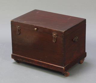 A rectangular mahogany trunk with iron drop handles, raised on ceramic casters 14"h x 18 1/2"w x 12 1/2"d 