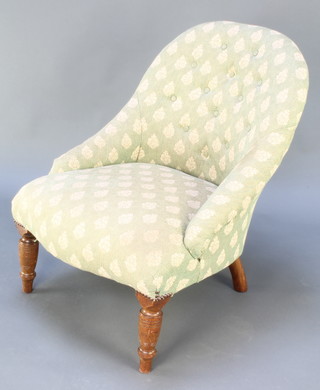 A Victorian iron metal framed nursing chair upholstered in green buttoned material raised on turned supports 