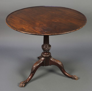 A circular Georgian mahogany snap top tea table, raised on a fluted column, tripod base, egg and claw feet 28"h x 34" diam. 