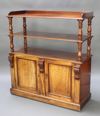 A William IV mahogany 3 tier buffet, the upper section with 3/4 gallery raised on turned columns, the base fitted a cupboard enclosed by panelled doors revealing a shelf to 1 side and cellarette drawer, raised on a platform base 52"h x 48"w x 18" 