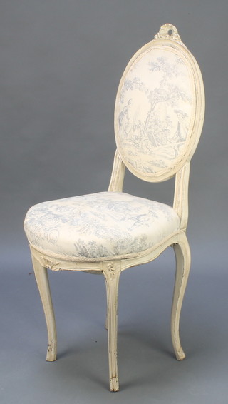 A 19th Century white painted French salon chair upholstered in patterned material, raised on cabriole supports