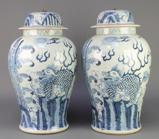 A pair of Chinese blue and white provincial oviform vases and covers decorated with dragons amongst trees, the lids with metal knops 19" 