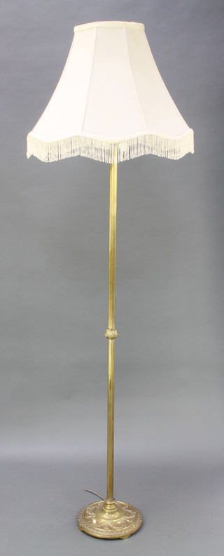 A reeded brass standard lamp, the base with swag decoration 