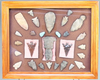 A collection of 27 native American Indian artefacts together with a carved stone figure of a Deity contained within a frame, the reverse marked George C Nickolas and with newspaper clipping 11" x 14