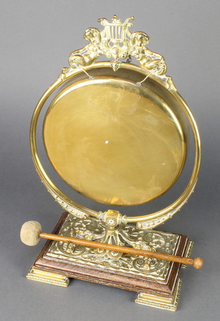 A Victorian brass table gong raised on an oak base 9" 