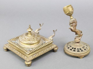 A Victorian pierced brass square standish fitted a glass inkwell and with dolphin pen rests, raised on bun feet 1" x 5" x 5" and a pierced gilt metal candlestick in the form of a rampant lion 6" (f)
