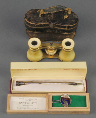 A pair of gilt metal and simulated ivory opera glasses, a propelling pencil contained in a sterling silver case, a gilt metal and enamelled tie container marked with the compliments from Katsuya Sato Governor of Nagasaki 