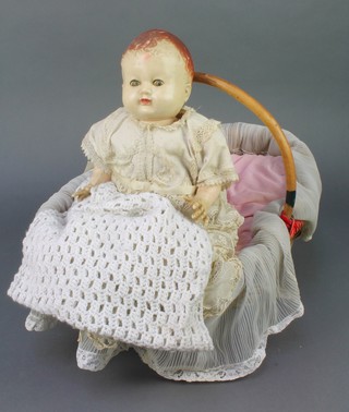 A plastic Pedigree doll with open and shutting eyes, contained in an oval wicker basket with bamboo handle (reputedly made by a German prisoner of war) together with a small card relating to the history of the doll 
