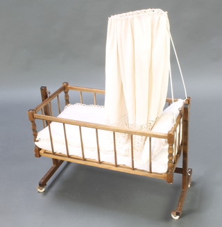 A child's toy rocking crib with canopy and turned decoration 19"h x 25"l x 13 1/2"w with label Gefrei Germany