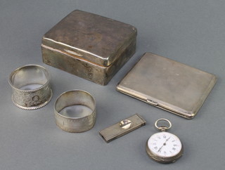 A silver engine turned cigarette case, 2 napkin rings, a cigarette box and pocket watch, weighable silver 180 grams