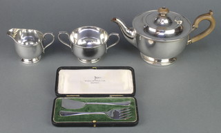 A silver plated 3 piece tea set and a cased pair of servers 