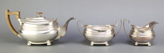 A silver plated tea set with egg and dart rim and fruitwood mounts on ball feet