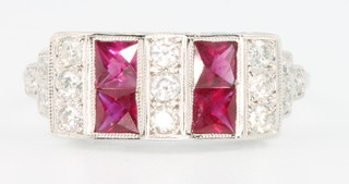 An 18ct white gold Art Deco style ruby and diamond ring with 4 princess cut rubies and 15 brilliant cut diamonds, size P 