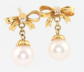 A yellow gold diamond and pearl ring, size O and a pair of ensuite earrings