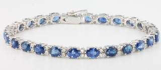 An 18ct white gold sapphire and diamond line bracelet, the oval cut sapphires 11.3ct interspersed with brilliant cut diamonds 0.74ct, 175 mm