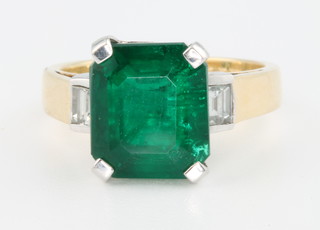An 18ct yellow gold emerald and diamond ring, the centre stone approx. 5.22ct flanked by 2 baguette cut diamonds approx. 0.43ct size N 1/2