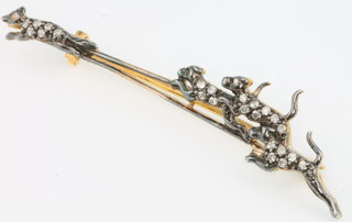 An Edwardian style yellow gold diamond set bar brooch in the form of 3 hounds chasing a fox, 65mm