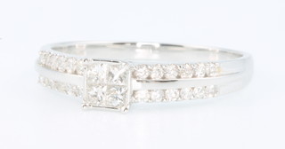 An 18ct white gold diamond ring with 4 princess cut diamonds and an open diamond set shank, size O