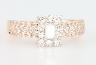 A rose gold diamond ring with centre baguette surrounded by brilliants the shank with brilliants size K 
