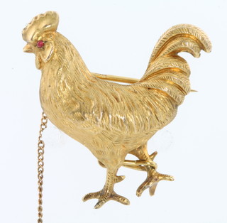 A high carat chased gold brooch in the form of a cockerel with ruby set eyes 8 grams