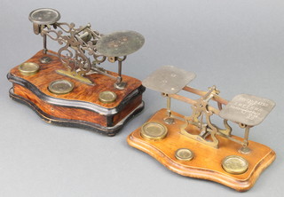A pair of 19th Century brass letter scales raised on a simulated walnut base of serpentine outline complete with 3 weights together with a pair of letter scales on a mahogany base with 3 weights 