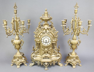 A reproduction 19th Century style French clock garniture comprising an 8 day striking clock contained in a gilt metal case surmounted by an urn 23"h x 15"w x 6 1/2"d  together with a pair of 5 light candelabrum 