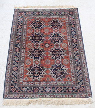 A Caucasian style brown and blue ground rug with 8 stylised medallions to the centre within multi row borders 73" x 50" 