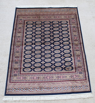 A blue and gold ground Bokhara style Belgian cotton rug with numerous octagons to the centre 76" x 52