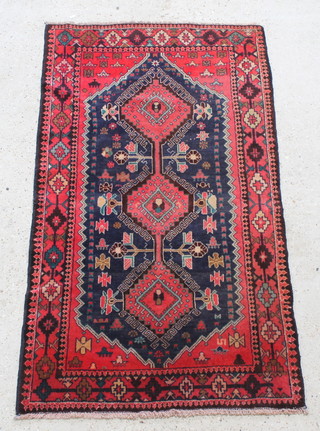 A red and blue ground Persian rug with diamond shaped medallion and having 3 diamond medallions to the centre 65" x 36" 