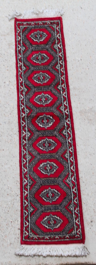 A red and brown ground Uzbek runner with 9 diamonds to the centre 61" x 13"