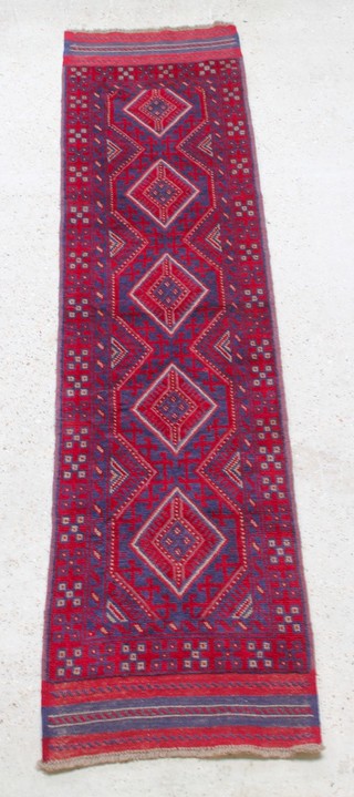 A red and blue ground Meshwani runner with 5 diamonds to the centre within a multi row border 101" x 25" 