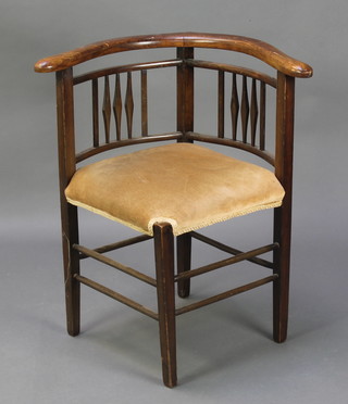 An Edwardian beech framed corner chair with upholstered seat, raised on square tapered supports 